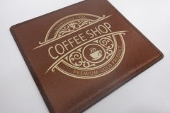 中央に湯気の立つコーヒーカップのアイコンが加工された四角形のレザー調オリジナルプリントワッペンの制作実績。