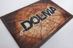 木の年輪を模した背景に、黒い太字で“DOLMA”の文字が中央に入った長方形オリジナルプリントワッペンの制作事例。