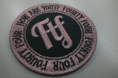 縁取りと文字をメタリックピンク糸で加工した、刺繍視覚的に強いインパクトを持つワッペンの制作見本。