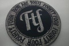 縁取りと文字はシルバーグレーの糸で刺繍した重厚で高級感のあるブランドのオリジナル円形刺繍ワッペン。