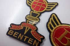 黒地に赤糸・金糸・黒糸を使った力強いデザインのクラブチームのオリジナル刺繡ワッペンの制作事例。
