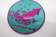 エメラルド地にピンクと黄色の糸で刺繡された目を引くオリジナル刺繡ワッペンの制作実績。