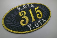 黒地に金色の縁取りと数字が、 誇り・格式・特別感を強く感じさせるオリジナル刺繡ワッペンの制作事例。
