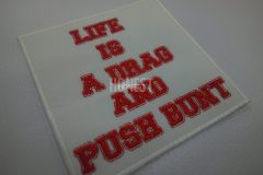 白地に赤糸だけのシンプルな文字だけのオリジナル刺繍ワッペンの制作事例。