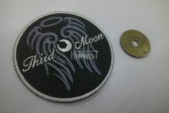 黒地に灰色と銀色の糸で刺繍された円形のオリジナルワッペンの制作事例。