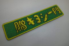 濃い緑色地に黄色い糸で縁取りされた横長の長方形のオリジナル刺繍ワッペンの制作実績。