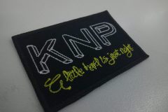 黒地に白と鮮やかな黄色糸で刺繍されたシンプルな四角いオリジナルワッペンの制作事例。