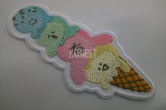 青・緑・ピンク・黄色の糸で表現された4段のアイスが積み重なっているゆるいキャラクターのオリジナル刺繍ワッペンの制作事例。