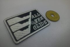 黒色の生地に白色で柄とALLTHEGLIDEの文字を刺繡した、オリジナル刺繡ワッペンの制作事例。