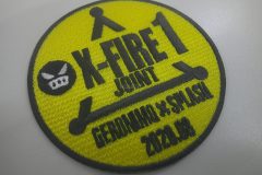 黄色の丸型ワッペン。黒い刺繍で「X-FIRE 1」「JOINT」「GERONIMO X SPLASH 2020.08」と描かれ、左に怒った表情の丸いキャラクターがあるオリジナル刺繡ワッペンの制作事例。