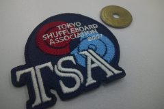シャフルボート協会のオリジナル詩趣ワッペン。紺生地をベースにワインレッド、サックス、ホワイトの糸で刺繍した作品。
