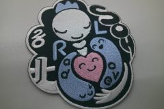 大学医学部のオリジナルロゴをツイル生地に白・ピンク・藤色で刺繍したオリジナルワッペンの加工実績。