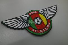 サッカーチームのテーマカラーである緑・赤・黄色を使用した明るく目を引くオリジナル刺繡ワッペン。羽ばたく羽とサッカーボールの模様も細かく刺繍した作品。