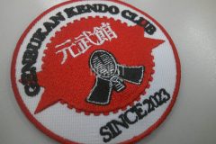 円形の中心に面のイラストを細かく刺繡した剣道教室の刺繍ワッペンの制作事例。