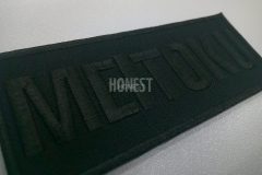 黒い生地に黒色の糸で学校名を刺繡した、シンプルな長方形の刺繍ワッペンの制作事例。