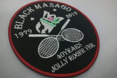 黒色に白でバドミントンのラケットとシャトルのキャラクターを刺繡したバドクラブのオリジナル刺繡ワッペンの制作事例。細かいデティールも高クオリティ。
