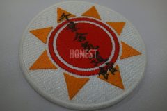 赤とオレンジ色の糸で太陽と、黒糸で合気道教室の名前を刺繡したオリジナル刺繡ワッペンの制作事例。