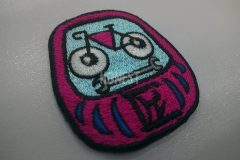 ダルマの顔を自転車とスパナで、お腹に匠の文字を入れたオリジナル刺繡ワッペンの制作事例。
