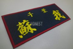 紺色の生地に黄色の糸で大きく蘇我の刺繡をし、赤色で縁の縫ったオリジナル刺繡ワッペンの制作事例。
