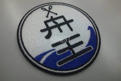 白色の生地に青色で波を表してチーム名と二本のオールを刺繡したオリジナル刺繡ワッペンの制作事例。