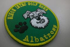 緑のアーバンツイル生地にゴルフ場の犬のキャラクターと足あとマークを加工した、刺繍ワッペンの制作事例。