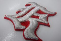 赤生地をベースに「K」の文字を銀糸で3D刺繍加工した、野球チームの刺繍ワッペン。