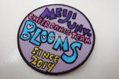 バイオレットカラーのツイル生地を土台に大学のダンスチームのロゴを多色で加工した、オリジナル刺繍ワッペンの制作事例。