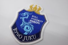 龍のシルエットと王冠のデザインをエンブレム調に加工した、空手道場のオリジナル刺繍ワッペン。