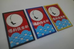 白い月に釣れた長靴が照らされた釣りクラブの刺繡ワッペン。波模様が立体的で縁の色が三種類ある作品。
