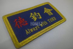 ネイビーの生地にメタリックゴールドの糸で釣りクラブの名前を刺繡し、縁を太くしたオリジナル刺繡ワッペンの制作事例。