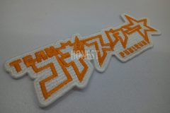 白色の生地にオレンジ色の糸で特徴的な文字でチーム名を刺繡した、オリジナル刺繡ワッペンの制作事例。