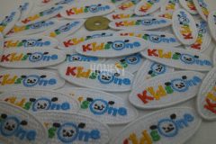 カラフルな配色で犬の顔が可愛い保育園のロゴ刺繡ワッペン。五円玉と比べてもほぼ変わらない高さの作品。