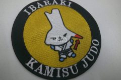 地域のご当地キャラクターが柔道着を着ているオリジナル刺繍ワッペン。黄色生地の中心にキャラクターを配置した作品。