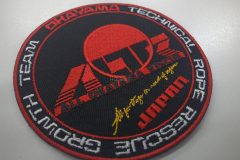 黒い生地に赤糸でロゴと日の丸を大きく刺繍し、団体名の刺繍で周りを囲んだオリジナル刺繡ワッペンの制作実績。