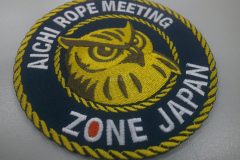 中心部に大きくフクロウが配置されており、文字をつな模様の刺繍で囲んだオリジナル刺繡ワッペンの制作実績。