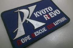 ロゴマークを大きく刺繍し、団体名を白糸と赤糸でアクセントを付けて刺繡した、オリジナル刺繡ワッペンの制作実績。