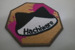 八角形の中心にハチワレ猫を刺繡したオリジナル刺繡ワッペンの制作実績。