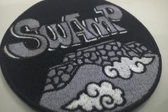 城の壁と雲をデザインし、SWAMPの文字が印象的な刺繡のオリジナル刺繡ワッペンの制作実績。