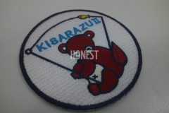 その土地にゆかりのあるタヌキが座って釣竿を持っているイラストを刺繡した、オリジナル刺繡ワッペンの制作実績。