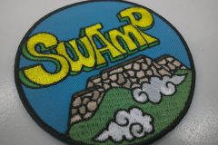 城の壁と雲をデザインし、SWAMPの文字が印象的な刺繡のオリジナル刺繡ワッペンの制作実績のカラーバージョン。