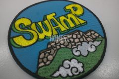 城の壁と雲をデザインし、SWAMPの文字が印象的な刺繡のオリジナル刺繡ワッペンの制作実績のカラーバージョン。
