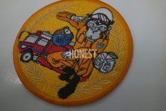 オレンジ色の生地に消防車と消防服を着たサルのイラストを大きく刺繡した、オリジナル刺繡ワッペンの制作実績。