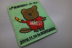 ビーバーが五輪のマークが描かれたセットアップを着てトーチを掲げているデザインのオリジナル刺繡ワッペンの制作実績。