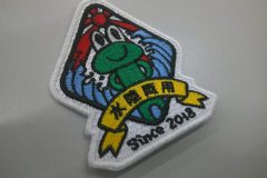 赤い太陽と荒波の真ん中にカエルが仁王立ちしているイラストを刺繡したオリジナル刺繡ワッペンの制作実績。