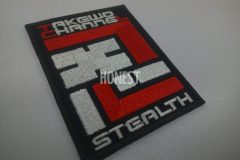 黒生地にチーム名と担当役割の文字を刺繡したオリジナル刺繡ワッペン「忍」の制作実績。