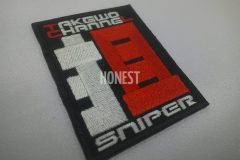 黒生地にチーム名と担当役割の文字を刺繡したオリジナル刺繡ワッペン「狙」の制作実績。