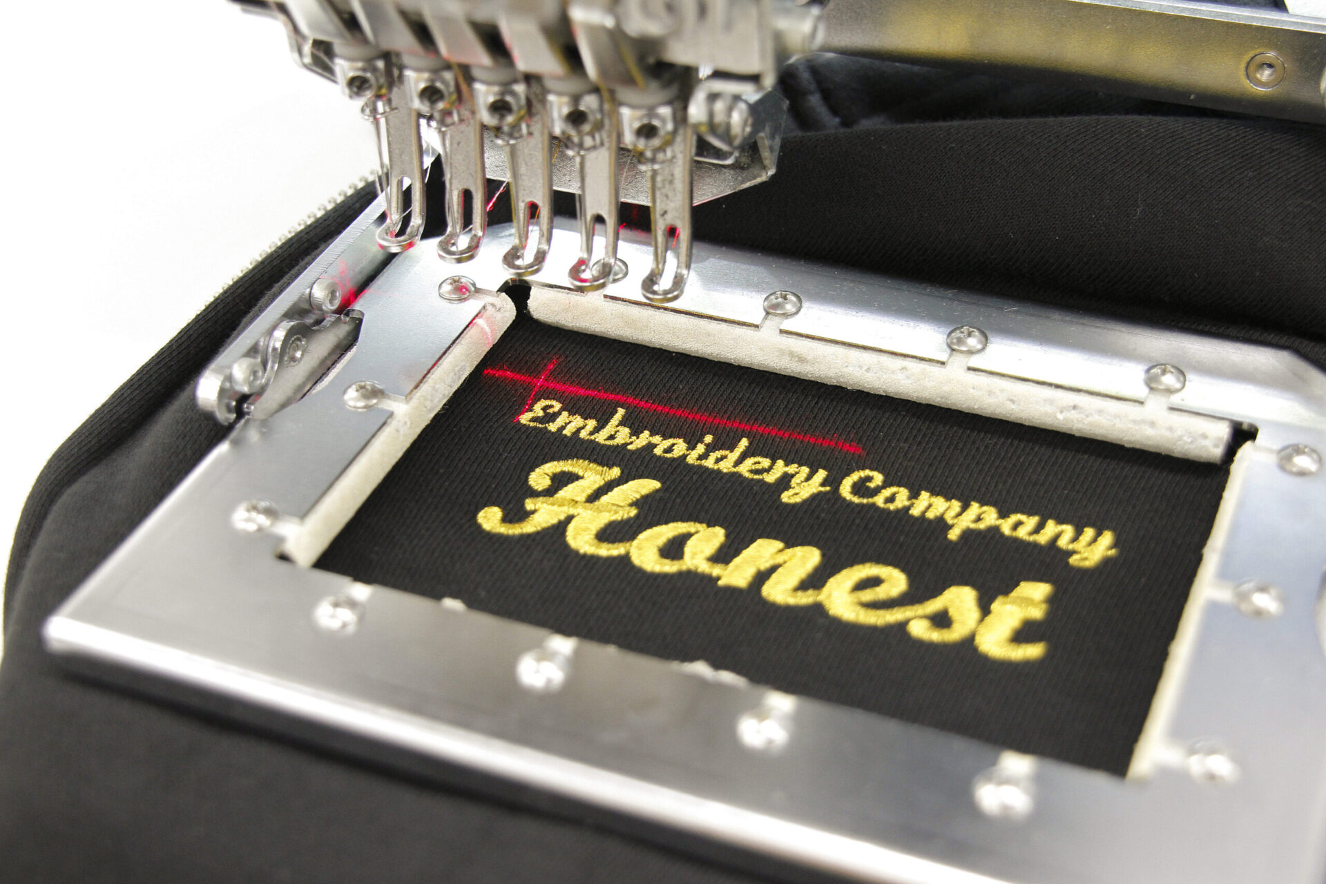 黒のスウェットに金糸でネーム刺繍をする作業工程。