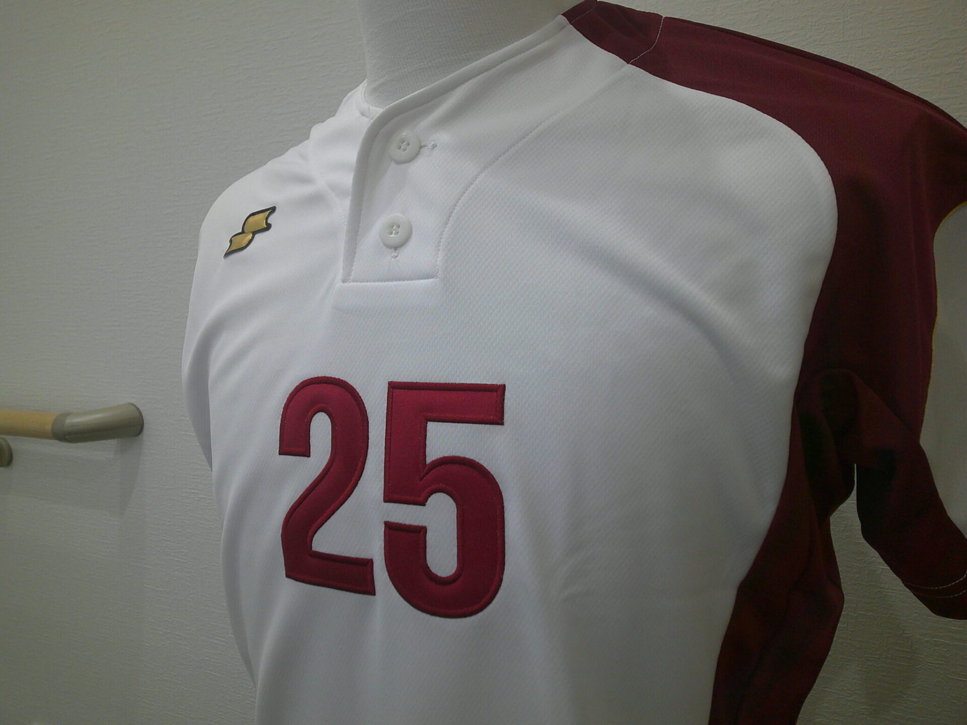 白/エンジのユニフォーム前面に25番の胸番号を縁取り刺繍した制作実績。