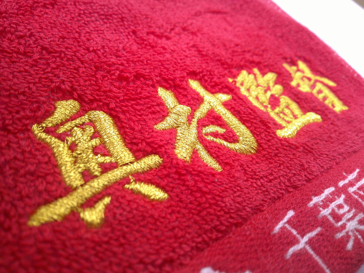 お持ち込みタオルに金糸で刺繍。書体は行書体を使用した制作事例。