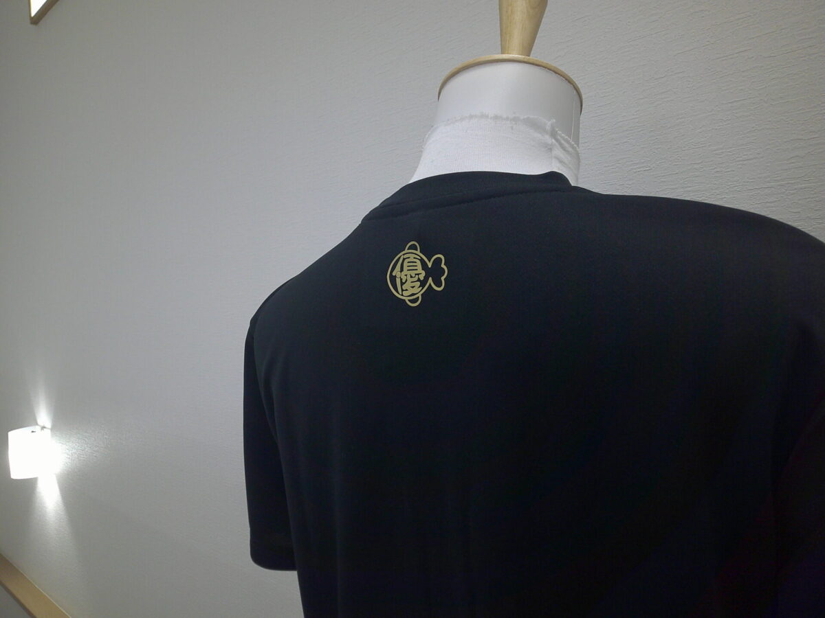 金魚のロゴデザインをゴールドカラーのラバーシートでラバープリントした加工実績。